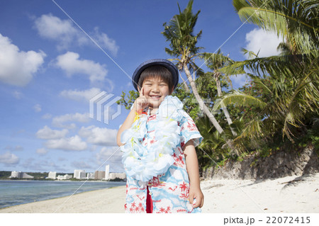 南国の風景とポーズする子供 22072415