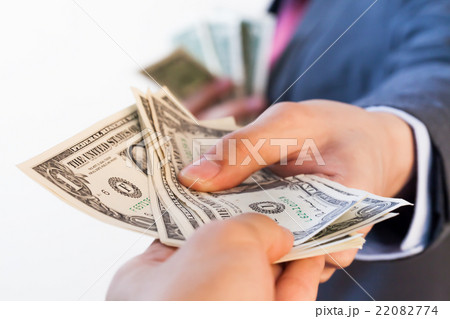 Business man giving bank notes to another person Business man giving bank notes to another person 22082774