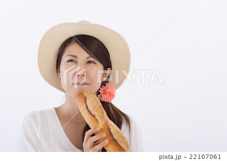 フランスパンを食べる可愛い女性の写真素材