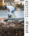 Man Cuts Tree Limbs with a Chainsaw Man Cuts Tree Limbs with a Chainsaw 22111428