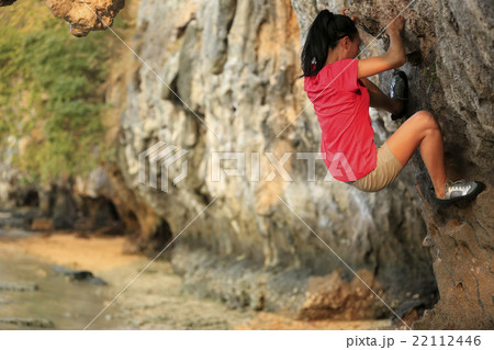 young woman rock climber climbing at seaside young woman rock climber climbing at seaside 22112446