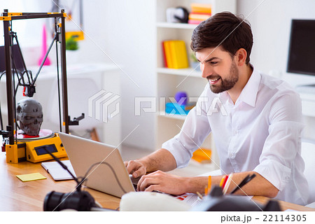Handsome smiling man using laptop Handsome smiling man using laptop 22114305