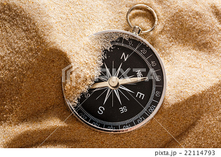 Black compass in beach sand 22114793