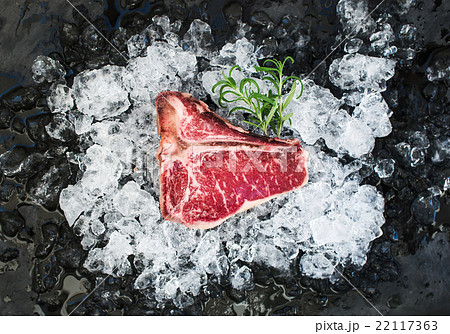 Raw fresh meat t-bone steak on chipped ice with 22117363