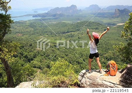 cheering successful woman hiker open arms at mountain peak 22119545