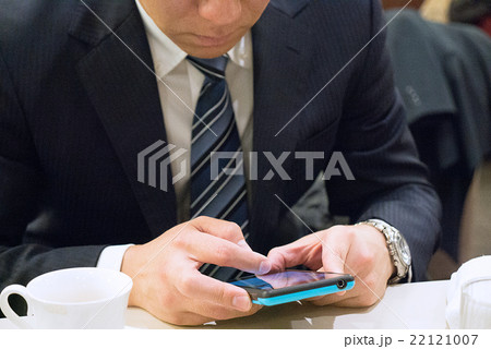 スマートフォンを操作するスーツの男性 スマートフォンを操作するスーツの男性 22121007