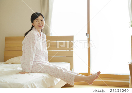 ベッドから起きる女性 22135040