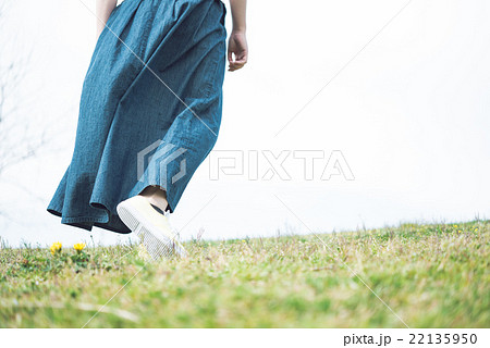 丘を歩く女性の写真素材