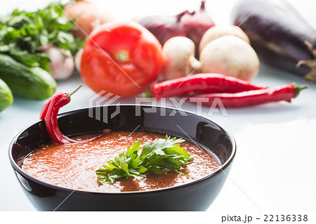 tomato soup in a black plate.  22136338