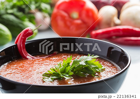 tomato soup in a black plate.  22136341