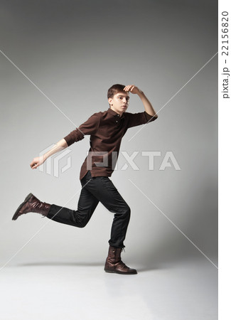 Young fashion male jumping on grey background 22156820