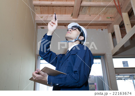建築現場で壁を確認するビジネスマン 建築現場で壁を確認するビジネスマン 22163674
