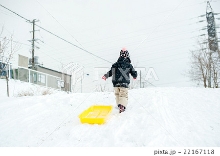 そりを引いて坂を上る子供の写真素材