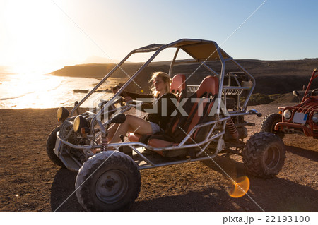 Woman driving quadbike in sunset. 22193100