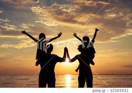 Silhouette of happy family who playing on the beach at the sunse 22203031