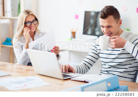 Positive guy drinking coffee at work   22208083