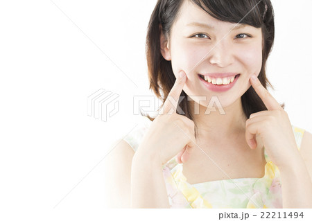 女性 美容 イメージ 私服 代後半から30代 えくぼに指を 笑顔 カメラ目線の写真素材