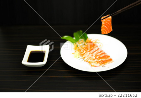 Chopsticks with sliced raw salmon lisolated 22211652