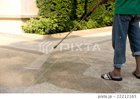 Worker cleaning dirty floor with high pressure jet 22212165