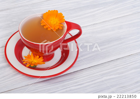 herbal tea with calendula flowers in a red cup herbal tea with calendula flowers in a red cup 22213850