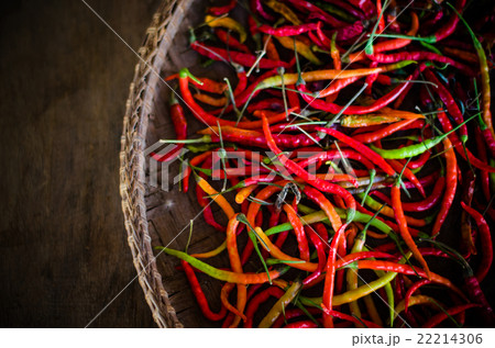 Several red and green hot chili peppers in basket 22214306