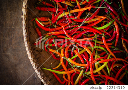 Several red and green hot chili peppers in basket 22214310