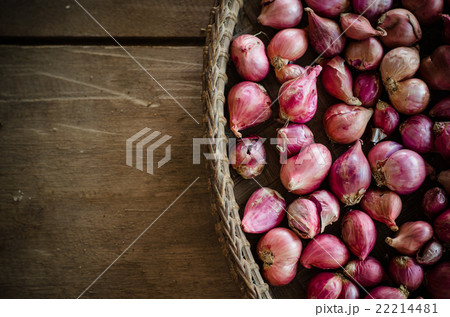 Several shallots in basket on wooden table 22214481