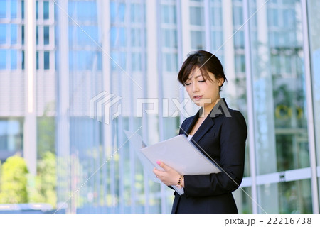 働く女性 オフィス街 スーツ姿で資料を手に c 働く女性 オフィス街 スーツ姿で資料を手に c 22216738
