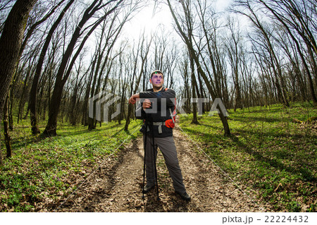 Male hiker looking to the side walking in forest 22224432