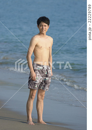 波打ち際でたたずむ若い男性 22229789