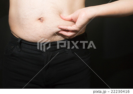 女性にお腹をさわられるメタボな男性のお腹 22230416