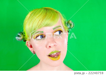 Beautyful young woman with green hair licking her lip on green background Beautyful young woman with green hair licking her lip on green background 22240759