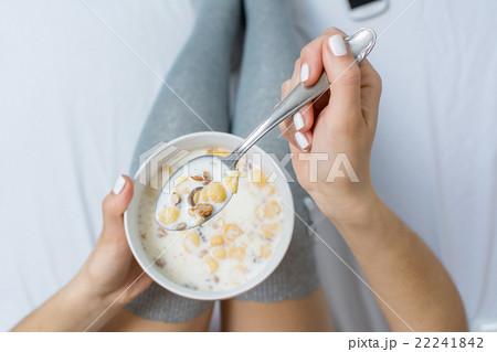 Woman eating cereals in bed Woman eating cereals in bed 22241842
