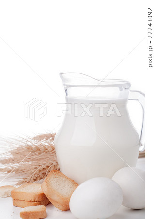 Glass jug with milk, wheat seeds and two eggs  22243092