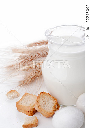 Glass jug with milk, wheat seeds and two eggs  22243095