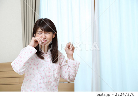 くしゃみをするパジャマの女性の写真素材