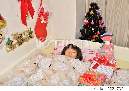 クリスマスプレゼントを待つ女の子 寝室 の写真素材