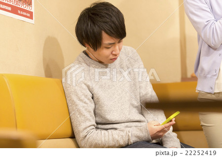 カラオケでスマホを弄る男性 カラオケでスマホを弄る男性 22252419