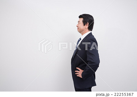 ミドルのビジネスマン 手を腰にポーズ の写真素材
