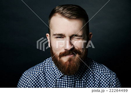 Winking red bearded man studio portrait on dark Winking red bearded man studio portrait on dark 22264499