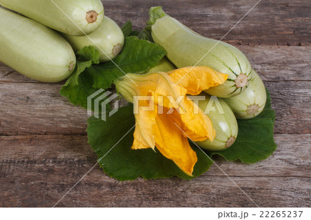 Fresh zucchini with leaves and flowers on a wooden Fresh zucchini with leaves and flowers on a wooden 22265237