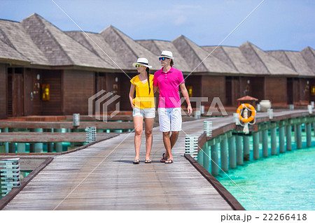 Happy couple on tropical beach jetty going to the 22266418