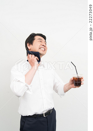 汗を拭きながらアイスコーヒーを飲むビジネスマン 22273049