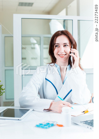 Woman doctor sitting at the table 22273489