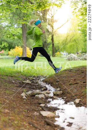 Sporty young female runner in city park.  22274849