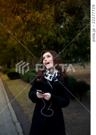 Beautiful girl listens to music in the park 22277729