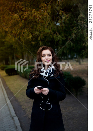 Beautiful girl listens to music in the park Beautiful girl listens to music in the park 22277745