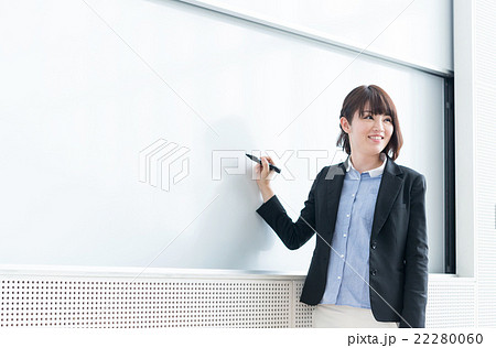 学校のホワイトボード前で教える笑顔の女性教師（30代・中年）ビジネス・教育シーン 22280060