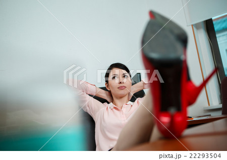 Relaxed businesswoman with legs on the desk 22293504