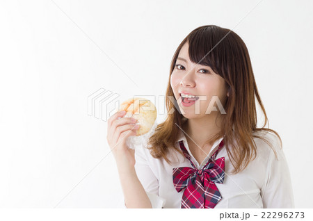 おいしそうにメロンパンを食べる女の子　右向き笑顔　昼食　食事　調理イメージ　女子高校生 22296273